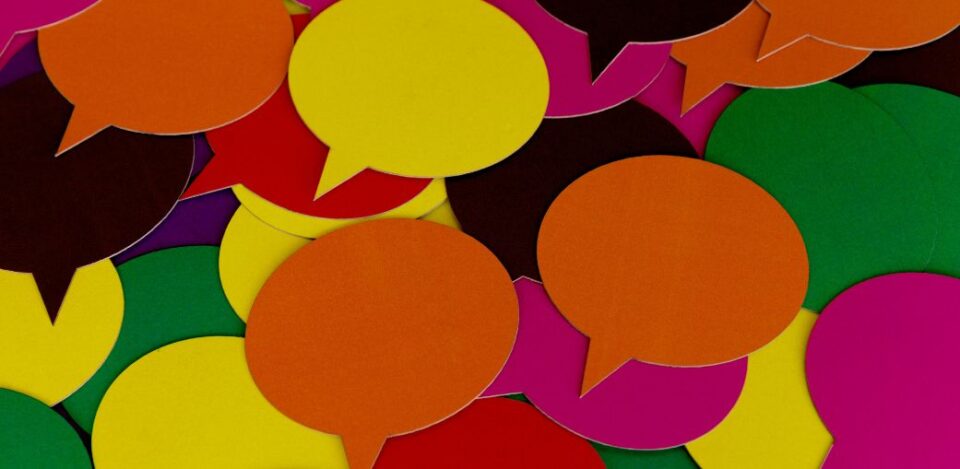 Bright, colorful paper speech bubbles arranged together, symbolizing communication and collaboration, representing a focus on uplifting educational initiatives