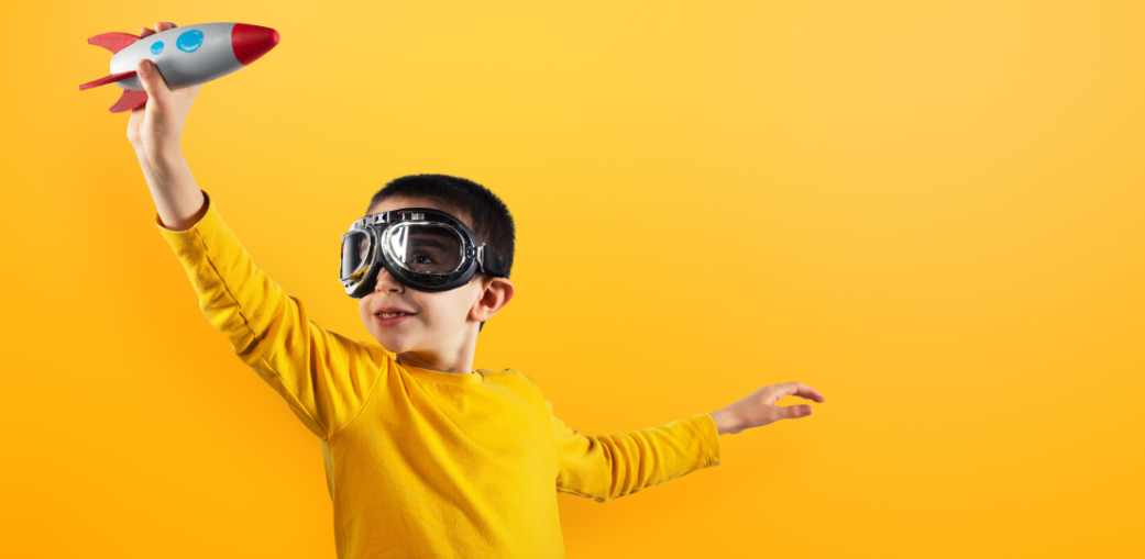 A young boy wearing goggles and a yellow shirt, engaging in a playful activity that encourages learning and exploration, illustrating the positive impact of ABA services for autism in building essential skills through structured, fun environments.