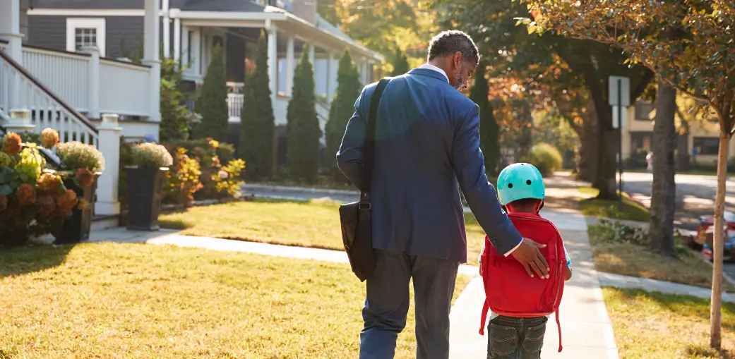Father walking his child to school on a sunny morning — representing the opportunities made possible by Ohio's scholarships for education. EA's school. Many locations in Ohio.