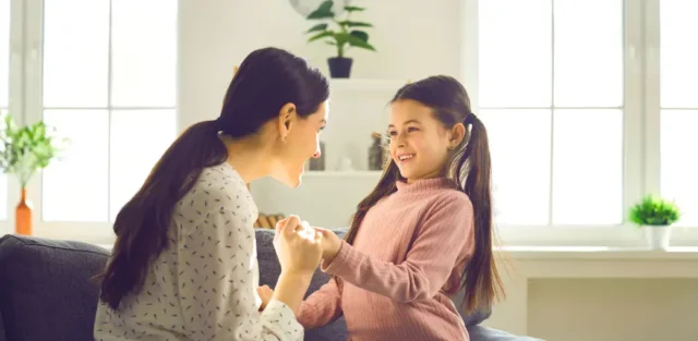 Parent celebrating with a smiling child at home, symbolizing positive growth and how families measure ABA progress together.