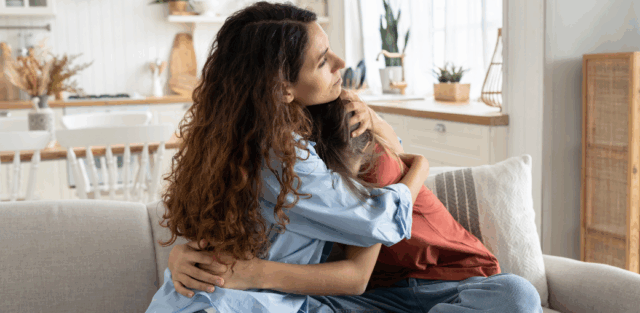 A mother gently hugs her child at home, offering comfort and reassurance while learning about autism and seizures.