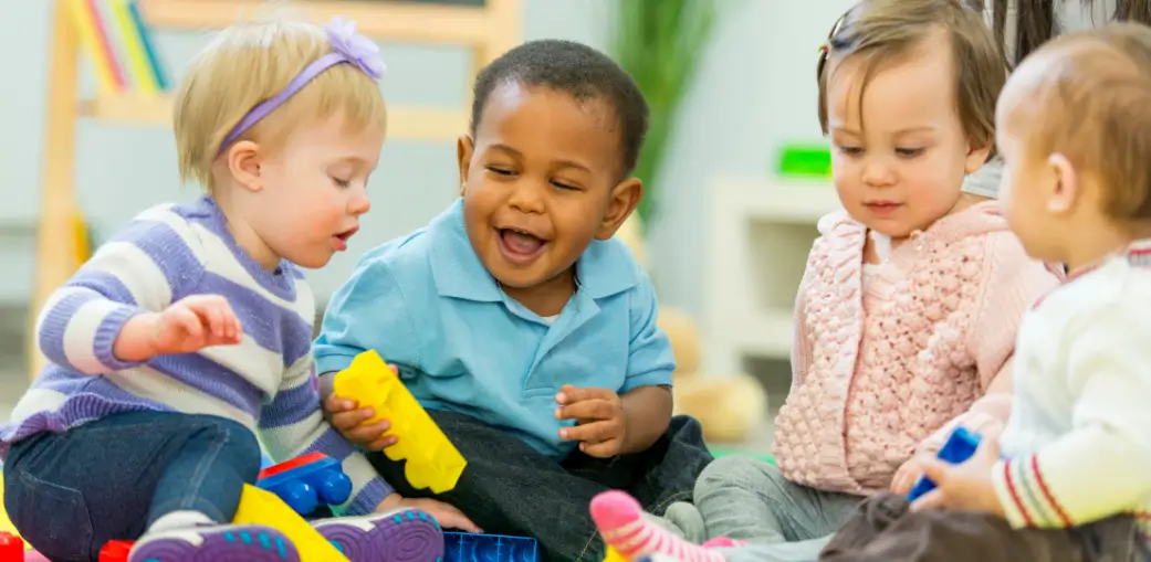 Toddlers playing with colorful blocks at EA Schools Ohio, where autism symptoms in 12-month-old babies can be evaluated early